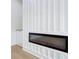 Modern fireplace with white paneling, built-in cabinets and wood-look floors at 217 W Bay St, Winter Garden, FL 34787