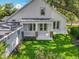 The rear of the beautiful white home features a covered porch, complemented by a lush green lawn at 217 W Bay St, Winter Garden, FL 34787