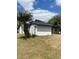 Charming home exterior with a palm tree accent, white walls, and dark roof, set in a sunny locale at 225 Ronnie Cir, Orlando, FL 32811