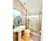 Bathroom with vanity, pedestal sink, framed mirror, tiled shower with glass door, and decorative finishes at 2346 Lily Pad Ln, Kissimmee, FL 34743