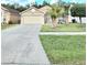 Beautiful home with a well-manicured lawn, mature trees, and a welcoming entrance at 2346 Lily Pad Ln, Kissimmee, FL 34743
