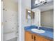 Bright bathroom featuring a tiled shower, vanity with sink, and blue countertop at 2401 8Th St, St Cloud, FL 34769