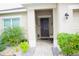 Inviting front entrance with brick pathway, manicured shrubs, and covered entry to the home at 247 Whispering Pines Way, Davenport, FL 33837