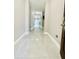 Long hallway with a glossy, light-colored tile floor leading towards the living areas at 247 Whispering Pines Way, Davenport, FL 33837