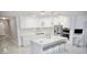 Modern white kitchen with stainless steel appliances and island with seating at 247 Whispering Pines Way, Davenport, FL 33837