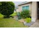 Landscaped yard with rock features, lush greenery, and manicured lawn surrounding the home's exterior at 247 Whispering Pines Way, Davenport, FL 33837