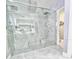 Luxurious walk-in shower with dual showerheads, bench seating, and modern fixtures at 247 Whispering Pines Way, Davenport, FL 33837