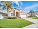 Charming two-story home boasts a well-manicured lawn, mature palm trees, and a two car garage at 2632 Emerald Island Blvd, Kissimmee, FL 34747