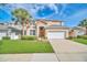 Charming two-story home featuring a well-manicured lawn, attached garage, and beautiful landscaping at 2632 Emerald Island Blvd, Kissimmee, FL 34747