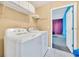 Bright laundry room with a full-size washer and dryer and convenient overhead shelving at 2632 Emerald Island Blvd, Kissimmee, FL 34747