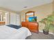 Spacious main bedroom featuring a king-size bed, a dresser with a TV, and a cozy ambiance at 2632 Emerald Island Blvd, Kissimmee, FL 34747