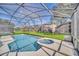 Relax in this beautiful screened-in pool and spa with views of the lush backyard at 2632 Emerald Island Blvd, Kissimmee, FL 34747