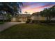 Charming home features a lush lawn, well-manicured landscaping, and a tile roof at sunset at 2746 Kissimmee Bay Cir, Kissimmee, FL 34744