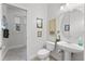 Chic half bath featuring modern fixtures, pedestal sink, and neutral color palette at 2746 Kissimmee Bay Cir, Kissimmee, FL 34744