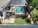 Aerial view of the screened pool, a patio, and a yard with grass and rocks at 2888 Spring Breeze Way, Kissimmee, FL 34744