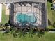 Overhead view of the refreshing pool with a screened-in enclosure, palm trees, and green grass at 2888 Spring Breeze Way, Kissimmee, FL 34744