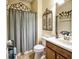 Charming bathroom with decorative ironwork, elegant vanity, and shower with curtain at 2888 Spring Breeze Way, Kissimmee, FL 34744
