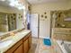 Spacious bathroom with double sink vanity, granite countertop, large mirror, shower and tub at 2888 Spring Breeze Way, Kissimmee, FL 34744