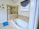 Bright bathroom features a soaking tub with tile surround and a separate glass-enclosed shower at 2888 Spring Breeze Way, Kissimmee, FL 34744