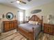 Warm bedroom with a wooden bed frame, tropical decor, wood-look floors, and ample natural light at 2888 Spring Breeze Way, Kissimmee, FL 34744