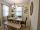 Bright dining room with modern chandelier, bench and table setting with neutral-toned decor at 2888 Spring Breeze Way, Kissimmee, FL 34744