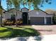 Charming single-story home with a three-car garage, landscaped yard, and brick paved driveway at 2888 Spring Breeze Way, Kissimmee, FL 34744
