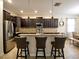Open kitchen with a large center island, stainless steel appliances, and dark wood cabinetry at 2888 Spring Breeze Way, Kissimmee, FL 34744