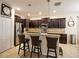Stylish kitchen featuring an island with seating, stainless steel appliances, and dark wood cabinetry at 2888 Spring Breeze Way, Kissimmee, FL 34744