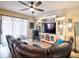 Inviting living room showcasing tile floors, a comfortable leather sectional, and modern entertainment center at 2888 Spring Breeze Way, Kissimmee, FL 34744