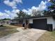 Exterior view of the home, featuring a lawn, an attached garage, and a charming front porch at 3045 Plaza Terrace Dr, Orlando, FL 32803