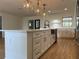 Bright kitchen featuring a large island, white cabinets, modern lighting, stainless steel appliances, and wood floors at 3045 Plaza Terrace Dr, Orlando, FL 32803