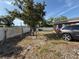 Spacious backyard with partial fence, mature tree, and ample open area, and parked SUV at 311 Congress Ave, Auburndale, FL 33823