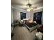 Primary bedroom with laminate flooring, ceiling fan, chair, bed, and minimal natural light at 311 Congress Ave, Auburndale, FL 33823