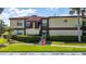 Condo building with well-maintained landscaping, tile roof, and neatly trimmed bushes at 3235 Candle Ridge Dr # 102, Orlando, FL 32822