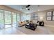 A modern living room with furniture and a ceiling fan has sliding glass doors to the lanai at 331 Alexandrite St, Deland, FL 32720