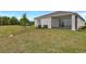 Spacious backyard with green grass, landscaping, and covered patio of house in background at 333 Alexandrite St, Deland, FL 32720
