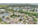 A sunny aerial shot of a subdivision, including a nearby pond, trees, and well-maintained lawns at 3886 Creek Bed Cir, St Cloud, FL 34769