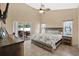 Serene main bedroom with rustic wood accents, a ceiling fan, and sliding door access to the lanai at 3886 Creek Bed Cir, St Cloud, FL 34769