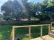 Large backyard with a wooden deck, lush green grass, and tall privacy fence at 4385 Ne 2Nd Ct, Ocala, FL 34479