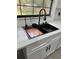 Close-up of kitchen sink with quartz countertops, modern black faucet and fixtures, and a stylish cutting board at 4385 Ne 2Nd Ct, Ocala, FL 34479