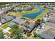 Beautiful aerial view of the property, backing onto a serene pond with neighboring homes and lush landscaping at 4739 Cumbrian Lakes Dr, Kissimmee, FL 34746