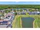 An aerial view shows a pond surrounded by homes with screened patios and private pools at 4739 Cumbrian Lakes Dr, Kissimmee, FL 34746