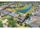 Aerial view of homes surrounding a neighborhood pond with fountains and swimming pools at 4739 Cumbrian Lakes Dr, Kissimmee, FL 34746