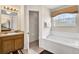 Bright bathroom featuring a soaking tub, large window, and modern vanity at 4739 Cumbrian Lakes Dr, Kissimmee, FL 34746