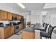 Open kitchen with wooden cabinets, stainless appliances and barstool seating plus a view to living area at 4739 Cumbrian Lakes Dr, Kissimmee, FL 34746