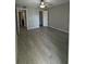Spacious bedroom with wood-look flooring, walk-in closet, ceiling fan, and gray painted walls at 5160 Conroy Rd # 26, Orlando, FL 32811