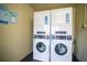 Clean laundry room featuring stacked washer and dryer units for convenience at 5245 W Irlo Bronson Memorial Hwy # 276, Kissimmee, FL 34746