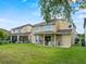 Backyard of home showcasing lawn and a covered patio with an outdoor kitchen at 5321 Los Palma Vista Dr, Orlando, FL 32837