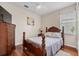 Cozy bedroom with a traditional wooden bed frame, dresser, hardwood floors and a bright window at 5321 Los Palma Vista Dr, Orlando, FL 32837