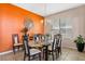 Inviting dining room with an orange accent wall and a stylish chandelier at 5321 Los Palma Vista Dr, Orlando, FL 32837